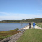 Menschen stehen auf einer Talsperre