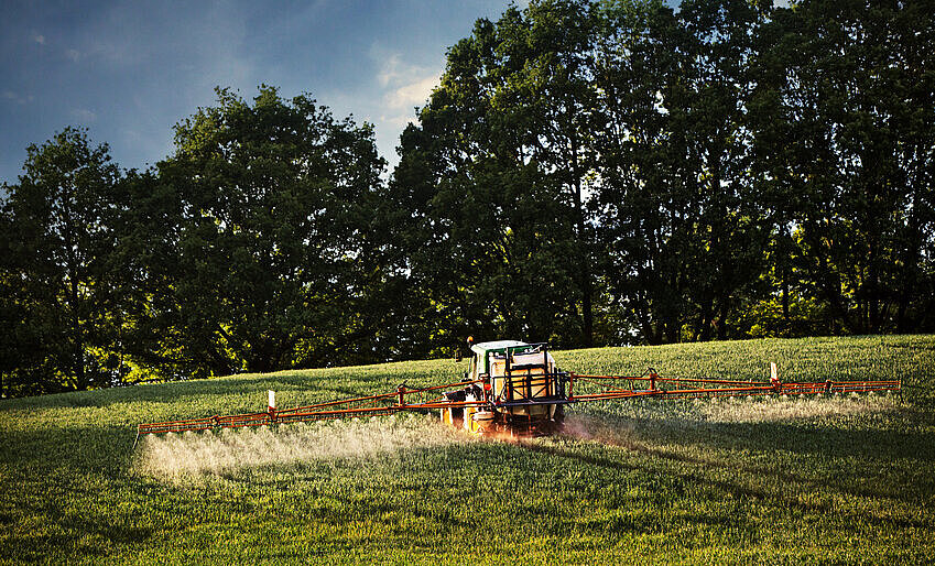 Ein Traktor bringt Pestizide aus
