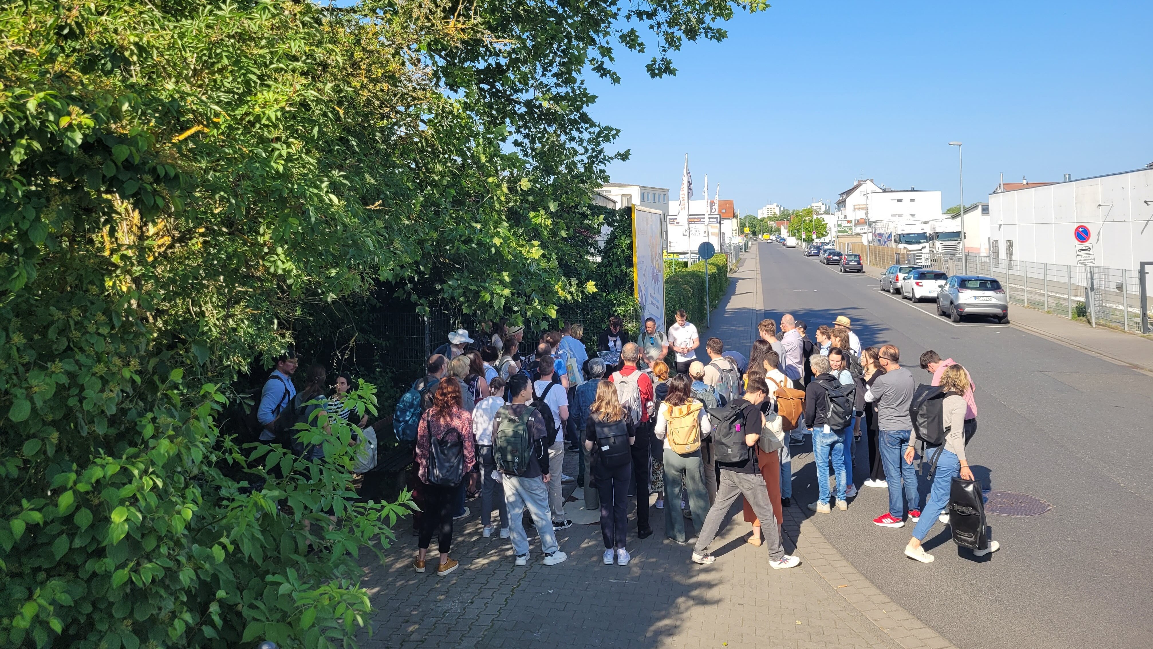 Eine Gruppe von Menschen auf Exkursion in einem Gewerbegebiet.